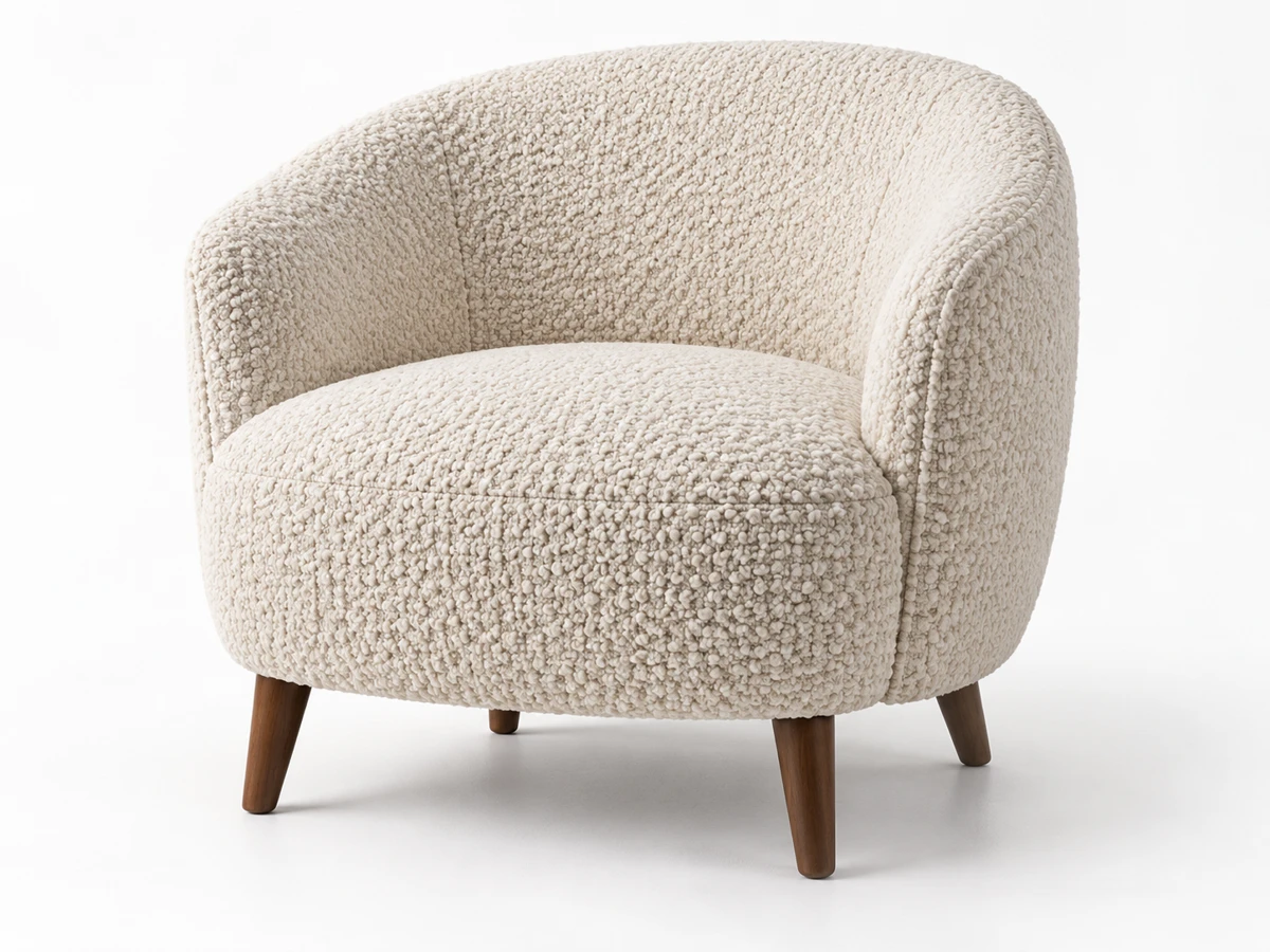 Sillón curvo tapizado en bouclé crudo de punto grueso, con costuras y trama visibles